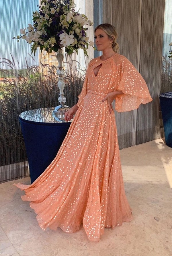 vestido de festa longo laranja claro com estampa de bolinhas douradas para casamento durante o dia