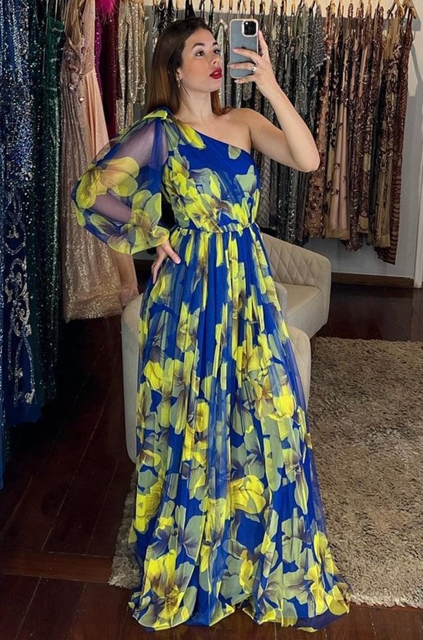 vestido de festa estampado azul royal com estampa de flores amarelas modelo um ombros só com uma manga longa