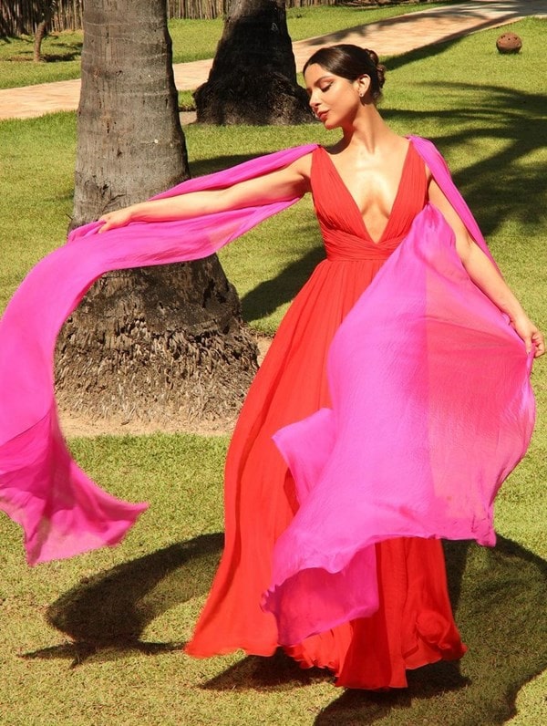 convidada de casamento na praia usando vestido longo vermelho  com manga capa pink