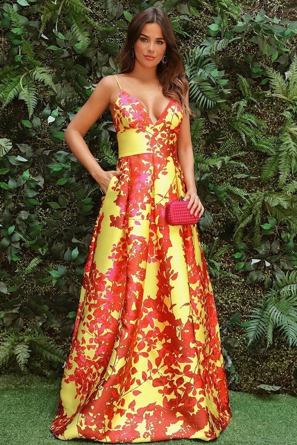 Vestido de festa amarelo com estampa floral vermelho. O modelo de zibeline possui alças finas, saia ampla com bolsa e cintura marcada