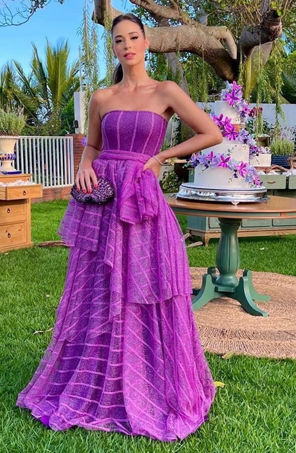 madrinha de casamento ao ar livre usando vestido longo fúcsia violeta