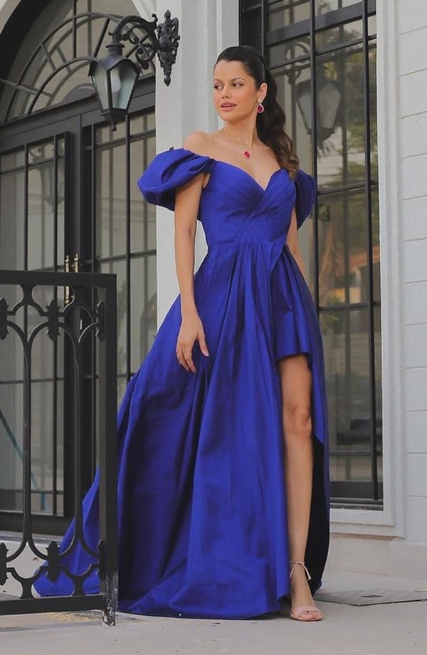 Vestido de festa longo azul royal com fenda frontal, volume na saia e decote ombro a ombro com manguinhas bufantes