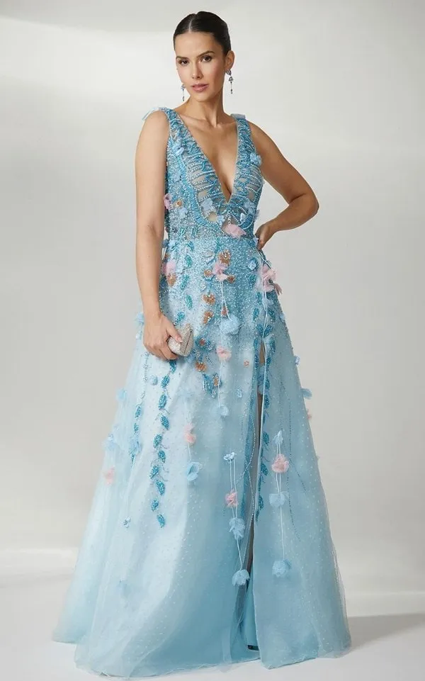 vestido longo azul claro com aplicação de flores 3d rose e azul. O vestido possui sobre saia de tule de de poás e fenda e decote em v