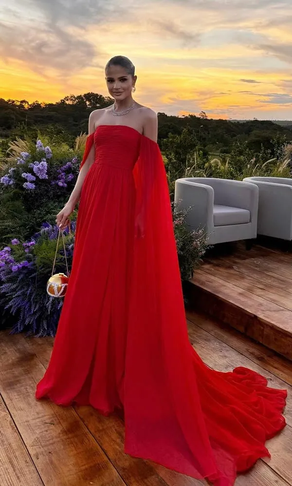 Thássia Naves usando vestido de festa longo fluiso vermelho om manga capa longa e decote ombro a ombro